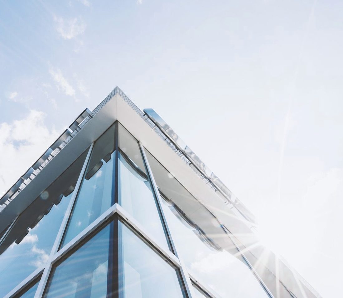 Immeuble de bureaux aux façades de verre baigné de soleil