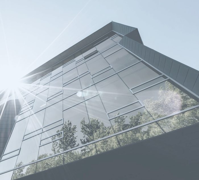 Façade vitrée d’un immeuble de bureaux moderne baignée de soleil